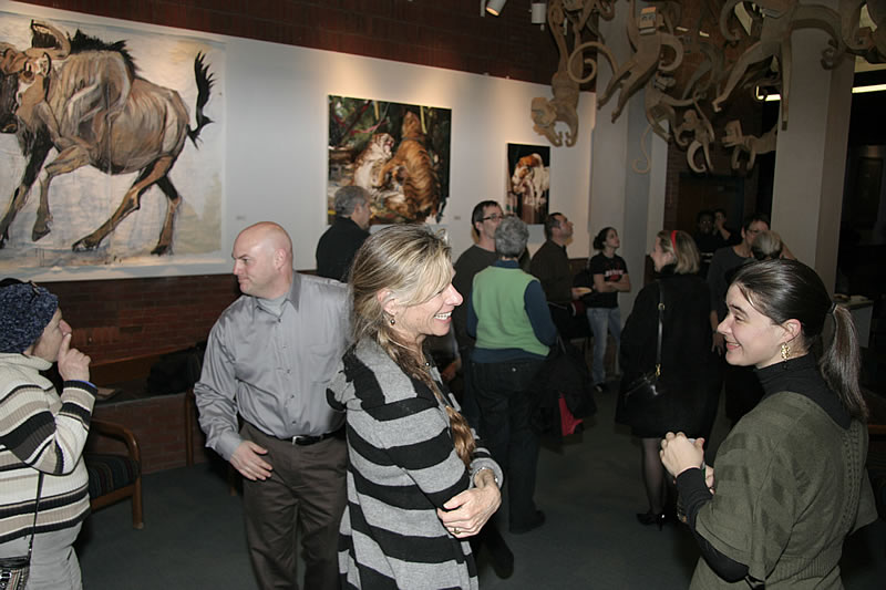 Foreground: Gallery Director Susan Hardesty on the left speaking with artist Gloria Adams at the opening reception for Zoology 101 at the NCC Art Gallery